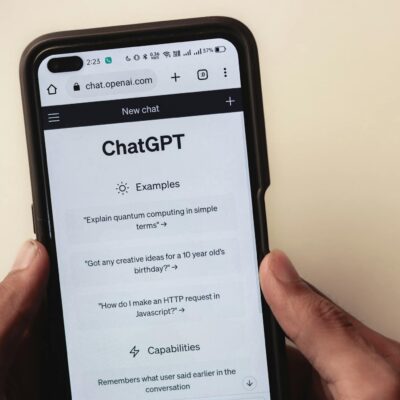 Close-up of hands holding a smartphone displaying the ChatGPT application interface on the screen.